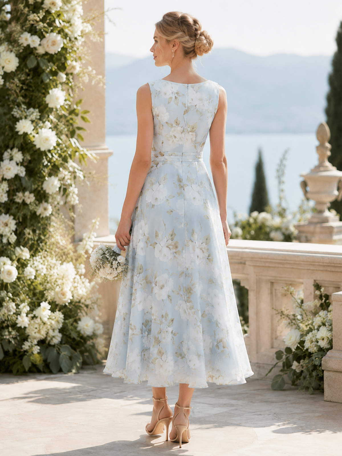 Light blue floral chiffon A-line tea-length bridesmaid dress back view with sleeveless bodice, defined waistband, and concealed zipper
