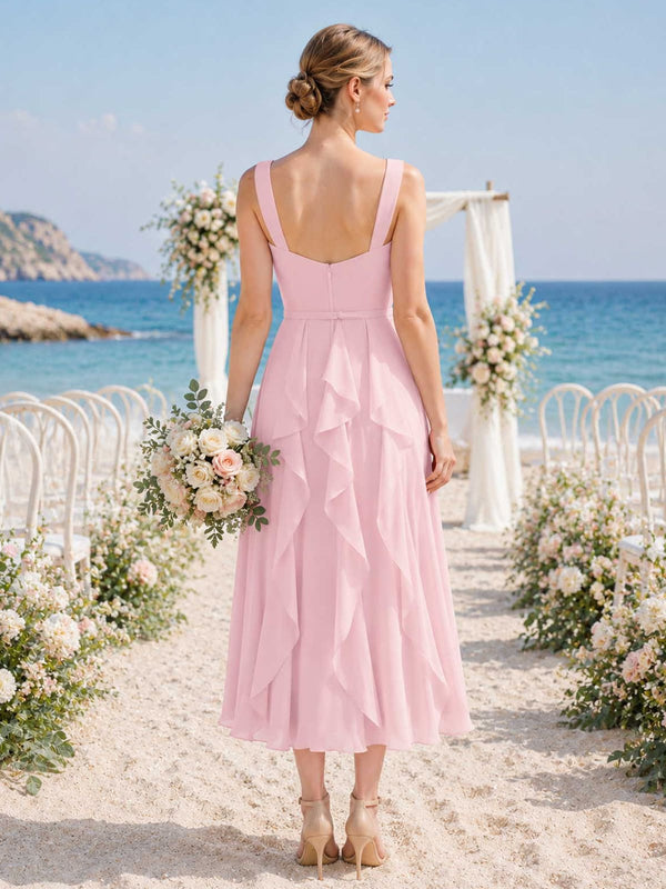 Blush chiffon bridesmaid dress with wide straps, square open back, center back zipper, cascading ruffle detail, and flowing midi A-line skirt