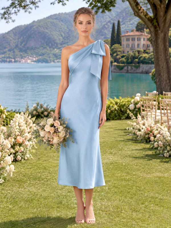 Light blue faux silk bridesmaid dress with one-shoulder neckline, shoulder bow, draped bodice, and midi sheath skirt