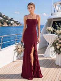 Front view of a burgundy chiffon floor-length bridesmaid dress with square neckline, spaghetti straps, front slit, cascading ruffle detail, and fitted mermaid-style skirt.