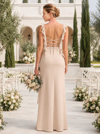 Back view of a champagne satin floor-length bridesmaid dress with ruffle straps, lace-up open back, tie detail, fitted waist, and elegant sheath skirt.
