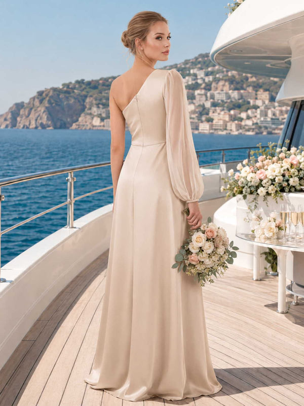 Back view of a champagne satin floor-length bridesmaid dress with asymmetric one-shoulder neckline, sheer organza long sleeve, fitted waist, center back closure, and softly flowing sheath skirt.