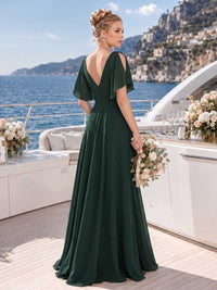 Back view of a dark green chiffon floor-length bridesmaid dress with deep V-back, cold shoulder flutter sleeves, fitted waist, and softly flowing A-line skirt.