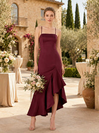 Front view of a burgundy satin midi bridesmaid dress with square neckline, spaghetti straps, fitted bodice, asymmetrical skirt detail, and elegant ruffle high-low mermaid hem.