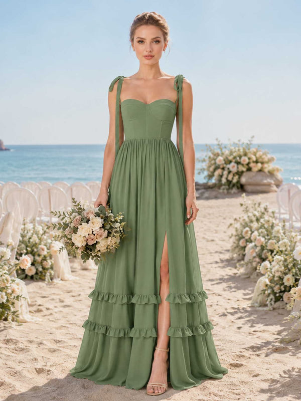 Front view of a sage green chiffon floor-length bridesmaid dress with sweetheart neckline, self-tie shoulder straps, structured fitted bodice, gathered waist, front slit, tiered ruffle hem, and flowing A-line skirt.