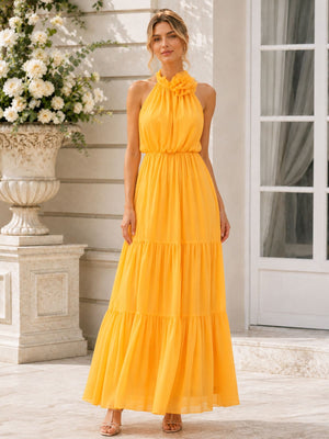 Front view of a marigold chiffon floor-length bridesmaid dress featuring a softly gathered halter neckline, floral neck detail, sleeveless bodice, defined natural waist, flowing A-line silhouette, and a romantic tiered skirt.