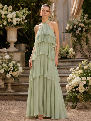 Front view of a sage green chiffon floor-length bridesmaid dress featuring a halter neckline, softly gathered bodice, cascading layered ruffles, tiered waist detailing, and a flowing A-line skirt.