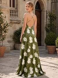 Back view of a floral imitation silk floor-length bridesmaid dress featuring delicate crisscross spaghetti straps, a dramatic open back, low V-shaped back construction, concealed center-back zipper, olive green floral print, and flowing A-line skirt.