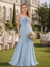 Front view of an ice blue chiffon floor-length bridesmaid dress featuring a strapless neckline, decorative bow and ruffle detail at the center bodice, fitted waist, and flowing A-line skirt.