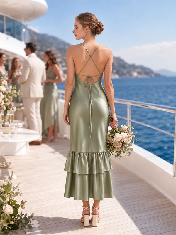 Back view of a sage green imitation silk midi bridesmaid dress featuring a deep open back, slim criss-cross straps, adjustable center-back tie, fitted sheath silhouette, and layered tiered ruffle hem.