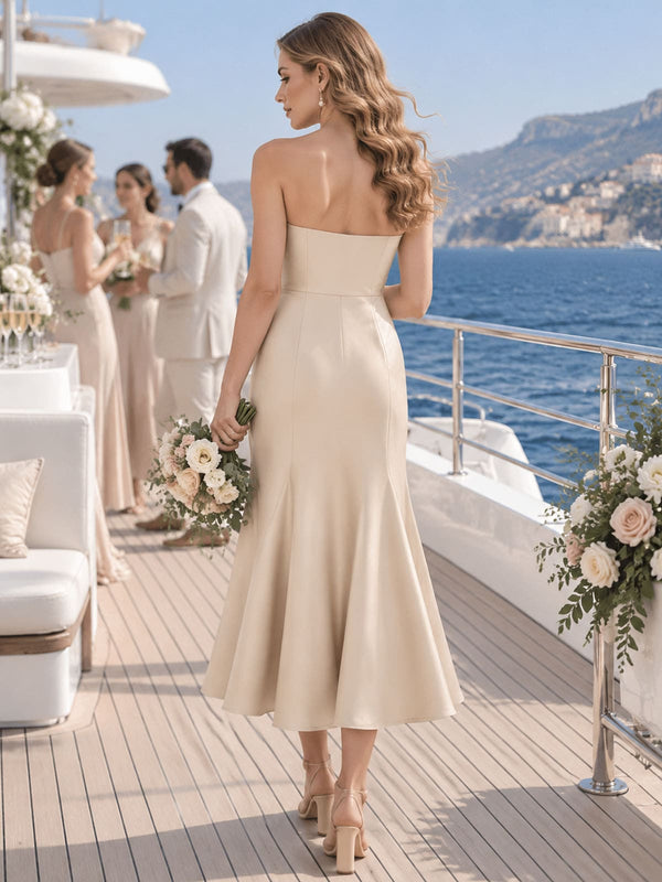 Back view of a champagne imitation silk bridesmaid dress featuring a clean strapless back, fitted bodice, defined waist, concealed center-back zipper, elegant fit-and-flare silhouette, and tea-length flared hem.