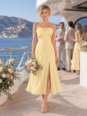 Front view of a daffodil chiffon bridesmaid dress featuring a strapless neckline, bow-trimmed bodice, fitted waist, front slit, elegant A-line silhouette, and tea-length hem.