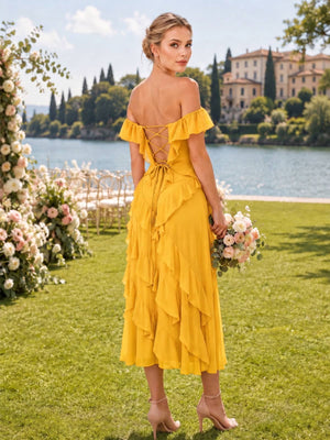 Back view of a marigold chiffon bridesmaid dress featuring an off-the-shoulder ruffled neckline, open lace-up corset back, fitted waist, cascading chiffon ruffles, and flowing ankle-length A-line skirt.
