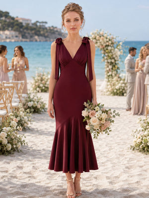 Front view of a burgundy imitation silk bridesmaid dress featuring a V-neckline, shoulder bow straps with ribbon tails, fitted bodice, elegant mermaid silhouette, and tea-length flared hem.