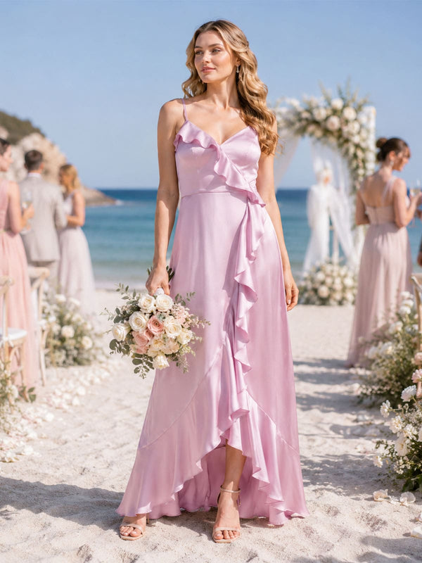Front view of a light pink imitation silk bridesmaid dress featuring a V-neckline, delicate spaghetti straps, cascading diagonal ruffles, fitted waist, flowing A-line silhouette, and an elegant asymmetric high-low skirt.