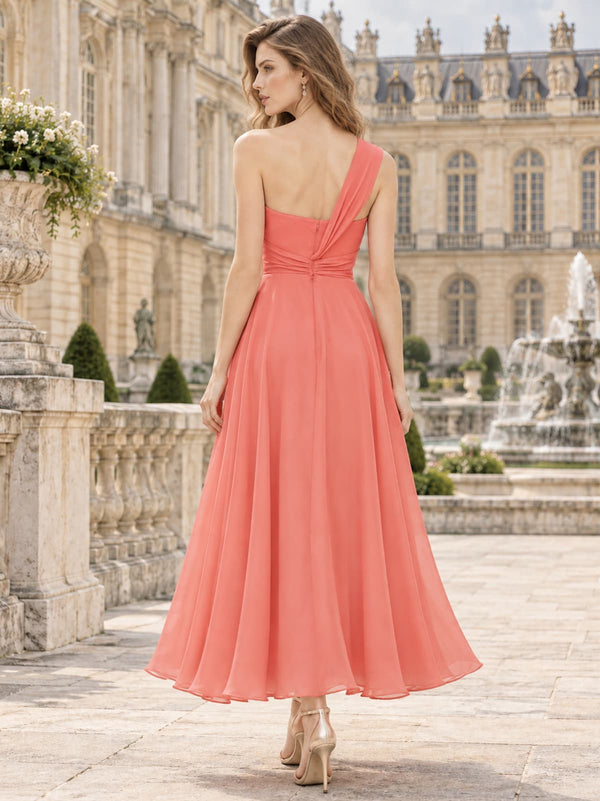 Coral chiffon one-shoulder tea-length bridesmaid dress with ruched waist and flowing A-line skirt, back view.