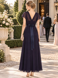 Plum chiffon V-neck bridesmaid dress with flutter sleeves, satin waist bow and flowing A-line skirt, back view