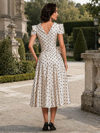 Polka dot print A-line midi evening dress back view with puff sleeves, fitted waist, and concealed zipper