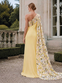 Floral one shoulder floor length evening dress back view with draped cape overlay