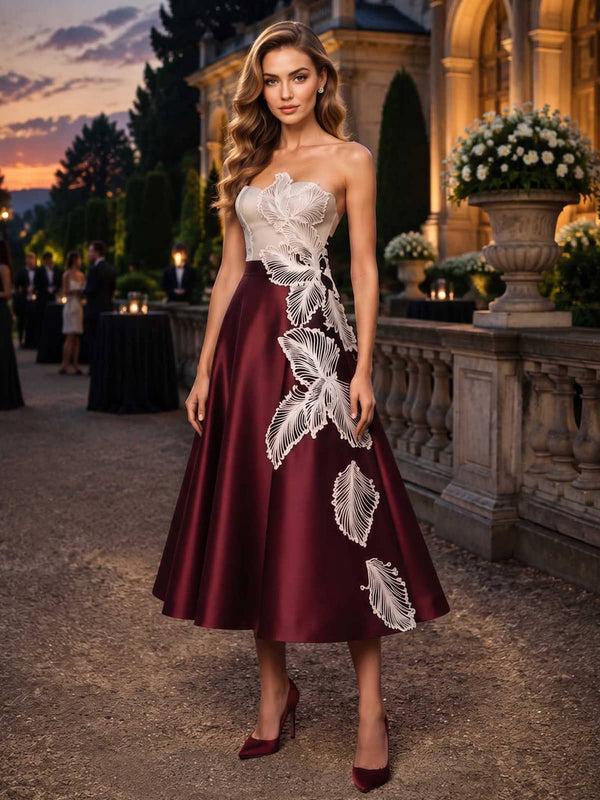 Satin mother of the bride dress front view with strapless neckline, fitted bodice, contrast lace applique detail, and tea length A-line skirt