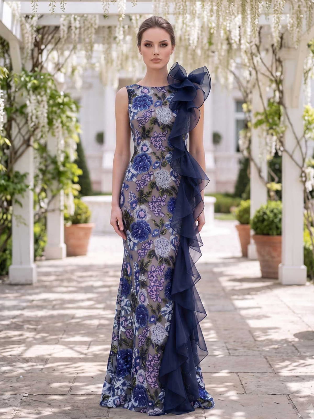 Floral lace mother of the bride dress front view with sleeveless neckline, navy tulle shoulder ruffle, fitted bodice, floral lace pattern, and floor length skirt