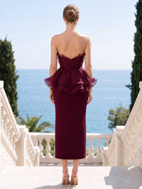 Burgundy satin organza mother of the bride dress back view with strapless bodice, concealed back zipper, layered organza peplum, and tea length slim skirt