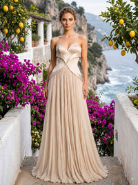 Champagne chiffon mother of the bride dress front view with strapless structured bodice, sculpted waist detail, pleated floor length skirt, and elegant formal silhouette