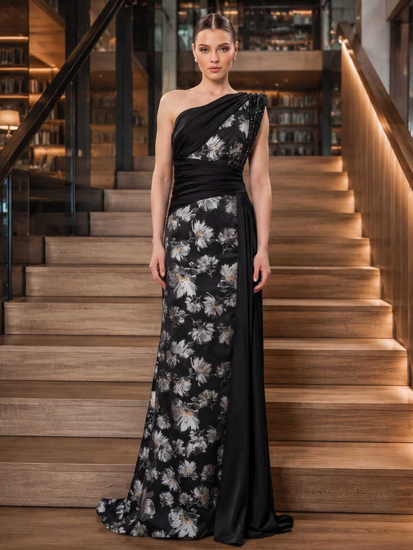 Floral jacquard satin mother of the bride dress front view with one-shoulder neckline, embellished shoulder detail, draped bodice, ruched waist, side drape, and floor length sheath skirt