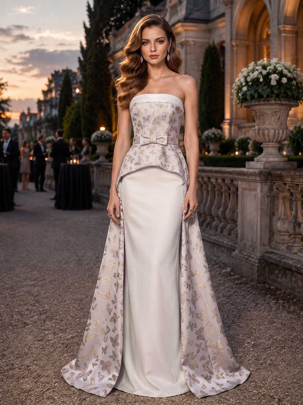 Butterfly jacquard satin mother of the bride dress front view with strapless neckline, fitted bodice, bow waist accent, satin sheath skirt, overskirt panels, and floor length silhouette