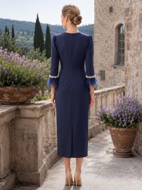 Navy blue satin mother of the bride dress back view with clean back, concealed zipper, tea length skirt, and three quarter sleeves with pearl feather cuffs