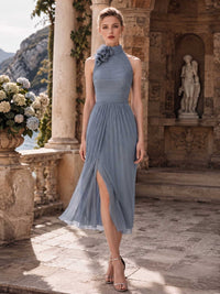 Dusty blue chiffon mother of the bride dress front view with halter neckline, floral shoulder detail, pleated bodice, midi skirt, and front slit