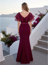 Back view of a burgundy satin floor-length mother of the bride dress with V-back neckline, layered organza ruffle cape sleeves, satin waistband, center-back zipper, fitted silhouette, and softly flared mermaid hem.