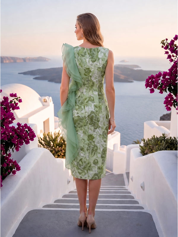 Back view of a green floral jacquard satin knee-length mother of the bride dress with bateau back neckline, fitted sheath silhouette, botanical jacquard pattern, center-back zipper, and layered mint organza ruffle cascading from the shoulder along one side.