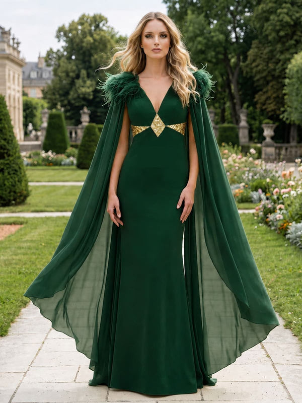 Front view of an emerald green chiffon floor-length mother of the bride dress featuring a deep V-neckline, fitted sheath bodice, feather-trimmed shoulders, long flowing chiffon cape sleeves, metallic gold waist embellishment, and an elegant straight floor-length skirt.