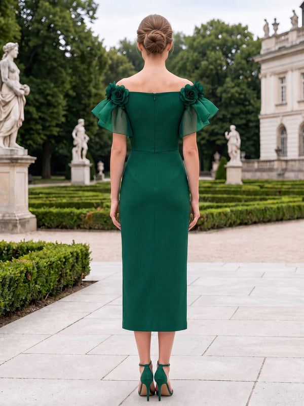 Back view of a tea-length mother of the bride dress featuring a straight off-the-shoulder back neckline, floral shoulder accents, organza flutter sleeves, a fitted satin sheath silhouette, and a center-back zipper.