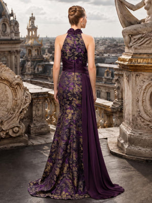 Back view of a floral jacquard satin floor-length mother of the bride gown with a high halter neckline, center-back zipper, fitted sheath silhouette, dark plum satin waist draping, and long coordinating side panel.