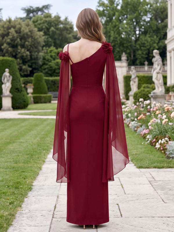 Back view of a wine red chiffon floor-length mother of the bride gown featuring an asymmetric back neckline, slim shoulder strap, three-dimensional floral shoulder accents, long flowing chiffon cape panels, fitted bodice, clean column skirt, defined waistline, and center-back zipper closure.