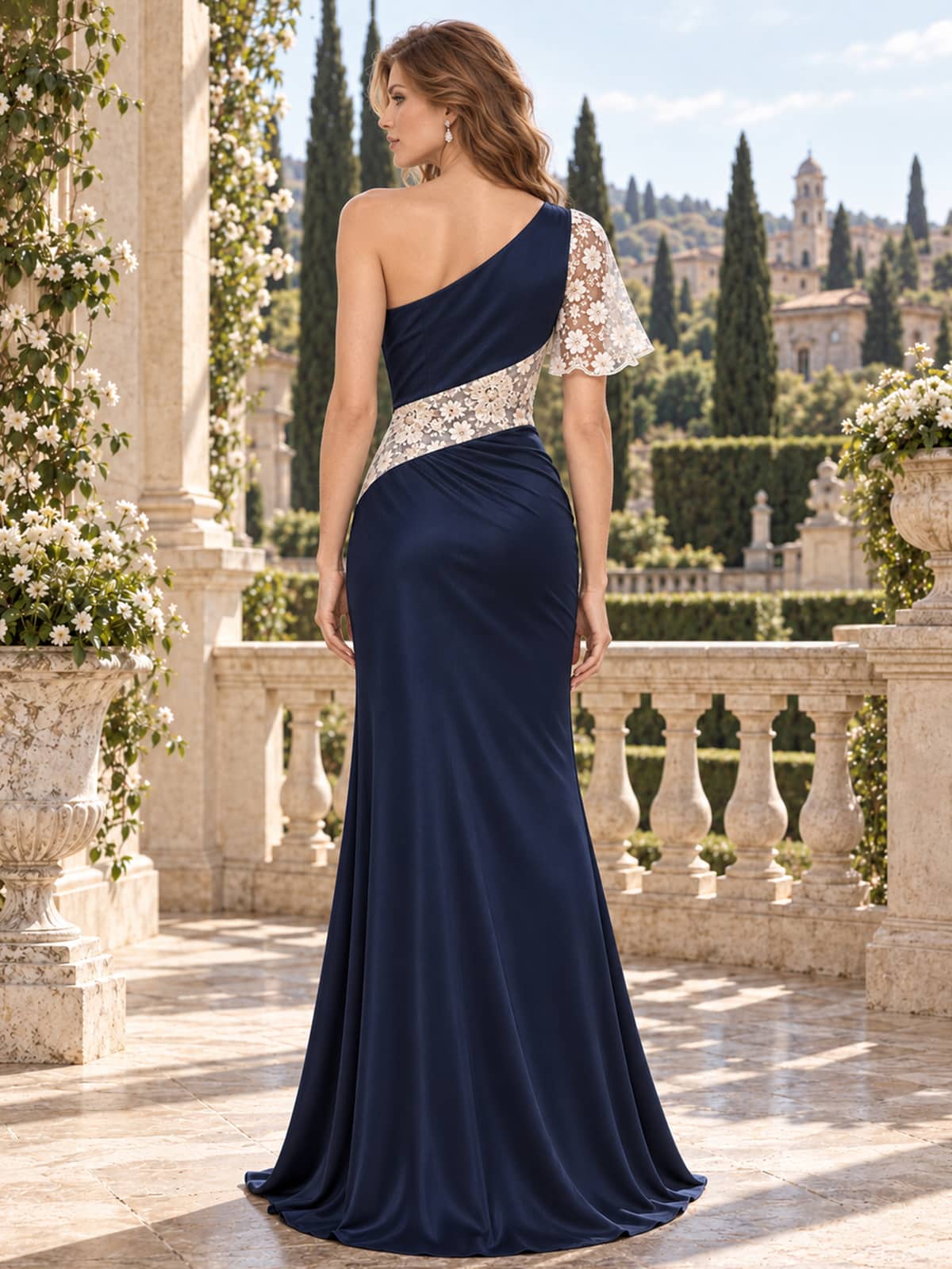 Back view of a navy satin and floral lace floor-length mother of the bride dress with an asymmetric one-shoulder design, floral lace panel, single lace sleeve, concealed back zipper, and mermaid silhouette.