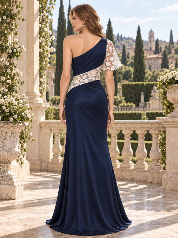 Back view of a navy satin and floral lace floor-length mother of the bride dress with an asymmetric one-shoulder design, floral lace panel, single lace sleeve, concealed back zipper, and mermaid silhouette.