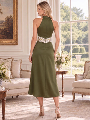 Back view of an elegant faux silk mother of the bride dress featuring a high halter neckline, sleeveless back, clean center-back construction, A-line midi skirt and contrasting embroidered floral waistband.