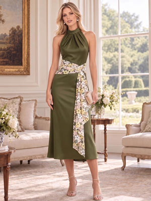 Front view of an elegant faux silk mother of the bride dress featuring a pleated halter neckline, sleeveless bodice, flattering A-line midi silhouette and contrasting embroidered floral sash wrapped around the waist with a long asymmetric draped detail.