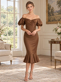 Front view of an elegant satin mother of the bride dress featuring an off-shoulder neckline, short sculpted puff sleeves, softly ruched wrap-style bodice, fitted mermaid silhouette and flounced midi hem.