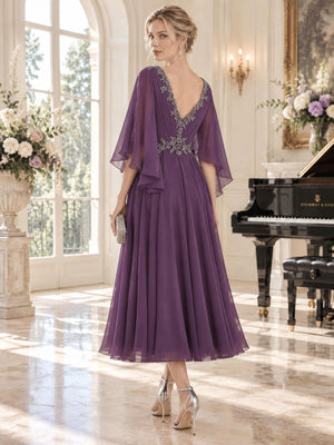 Back view of an elegant chiffon mother of the bride dress featuring a deep V-back with intricate beadwork, embellished waist, flowing cape sleeves and a softly gathered tea-length A-line chiffon skirt.