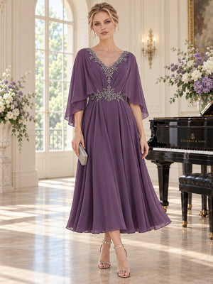 Front view of an elegant chiffon mother of the bride dress featuring a V-neckline with sheer illusion inset, intricate beaded neckline and waist embellishments, flowing cape sleeves, softly gathered bodice and tea-length A-line skirt in a muted purple tone.