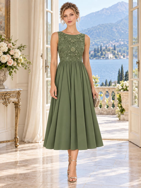 Front view of an elegant sage green chiffon mother of the bride dress featuring a bateau neckline, sleeveless floral beaded bodice, dimensional floral embellishments, defined natural waist and softly gathered tea-length A-line chiffon skirt.