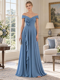 Front view of a dusty blue chiffon mother of the bride dress featuring an off-the-shoulder neckline, softly pleated wrap-style bodice, chiffon floral appliqués at the waist, cascading draped detail and a flowing floor-length A-line skirt.