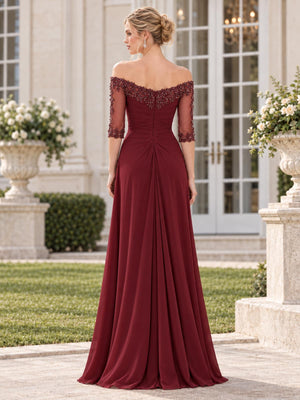 Back view of a burgundy chiffon and floral lace mother of the bride dress featuring an off-the-shoulder floral lace neckline, sheer beaded lace sleeves, ruched waist, concealed center-back zipper and flowing floor-length skirt.