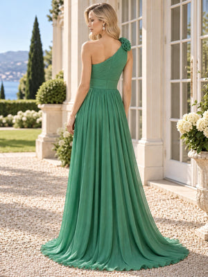 Back view of a green chiffon mother of the bride dress featuring an asymmetric one-shoulder design with dimensional floral appliqué, ruched bodice, defined waist, concealed back zipper and full flowing floor-length A-line chiffon skirt.
