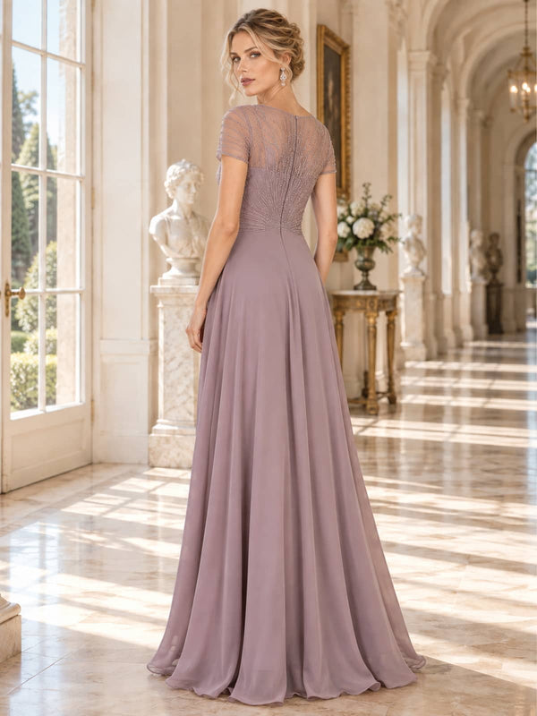 Back view of a floor-length lace and chiffon mother of the bride dress featuring a sheer embellished upper back, short sleeves, radiating bead and embroidery detailing, concealed center-back zipper and flowing A-line chiffon skirt.
