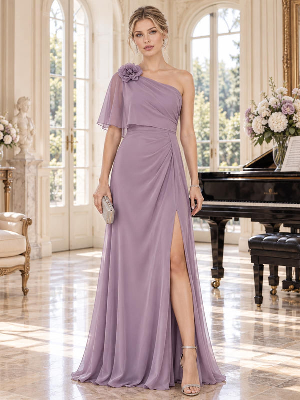 Front view of a dusty lavender chiffon mother of the bride dress featuring an asymmetric one-shoulder neckline, dimensional flower appliqué, flowing chiffon cape, softly draped waist, front slit and floor-length A-line skirt.